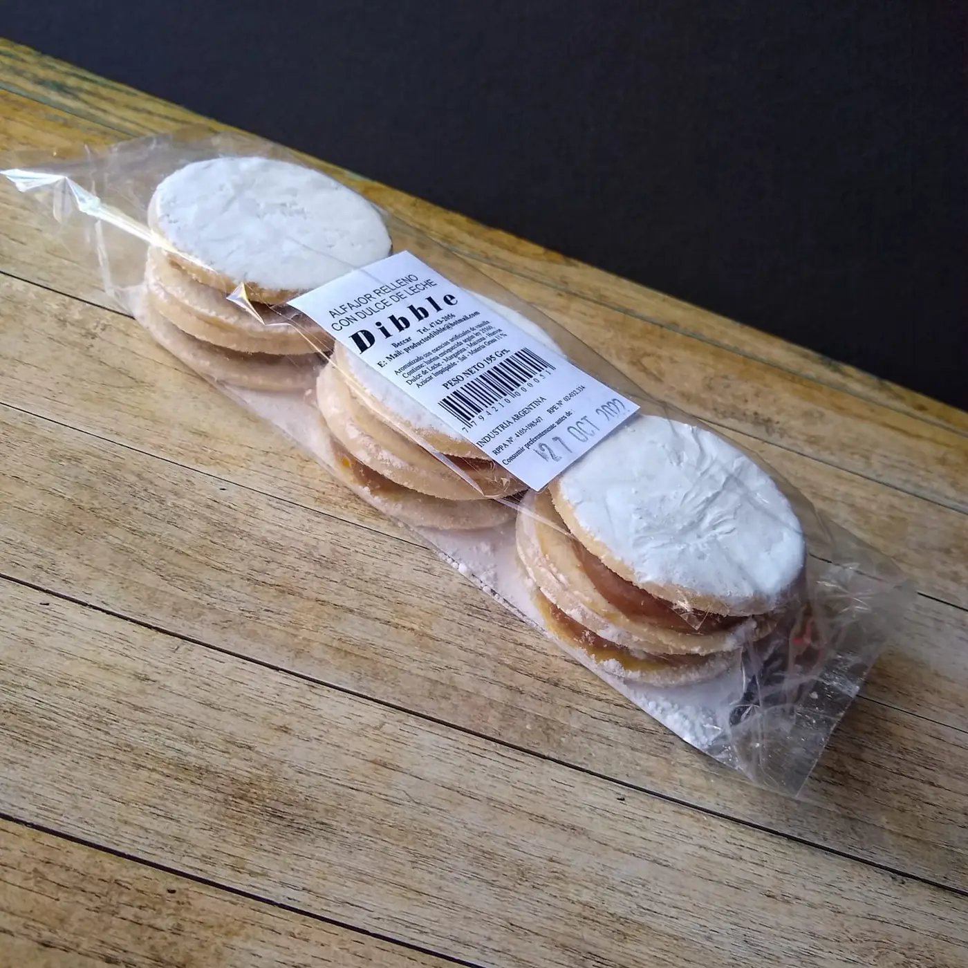 Alfajores clásicos x3 con etiqueta Dibble sobre tabla de madera